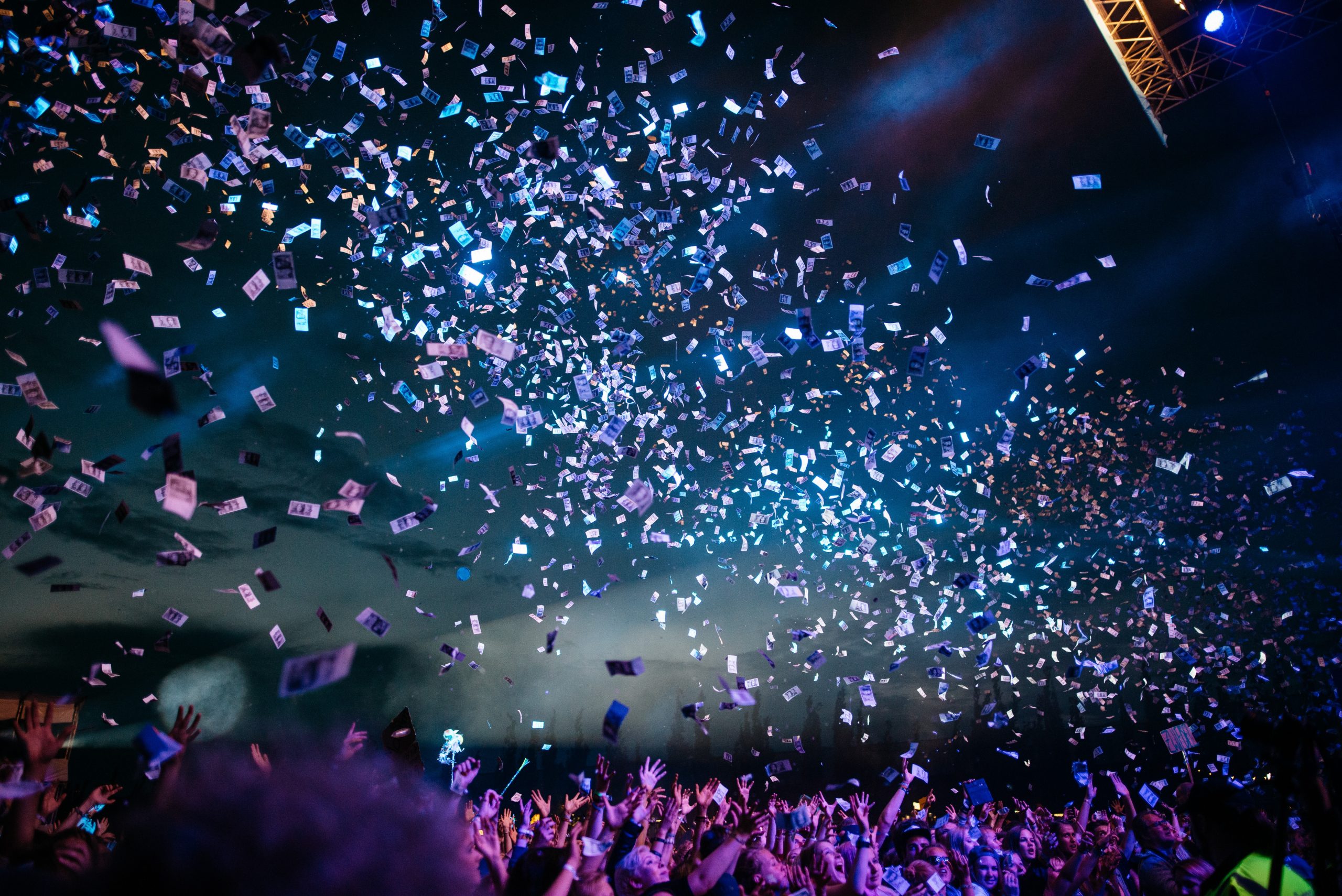 Multidão eufórica comemorando sob uma explosão de confetes em vibrantes festas universitárias.