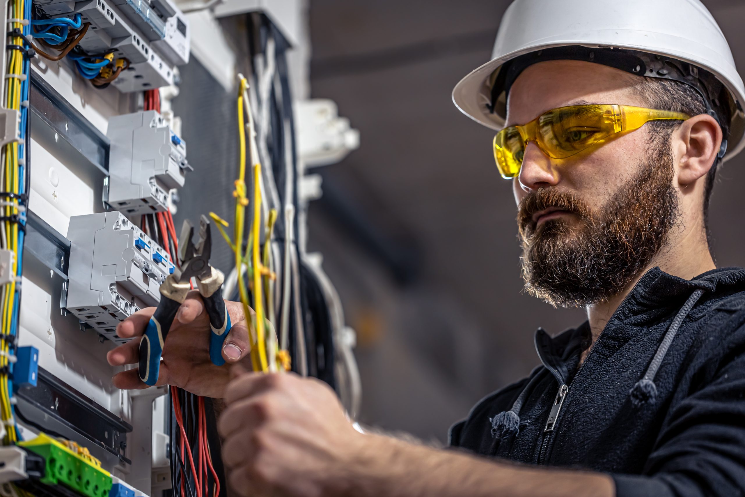a-male-electrician-works-in-a-switchboard-with-an-electrical-connecting-cable