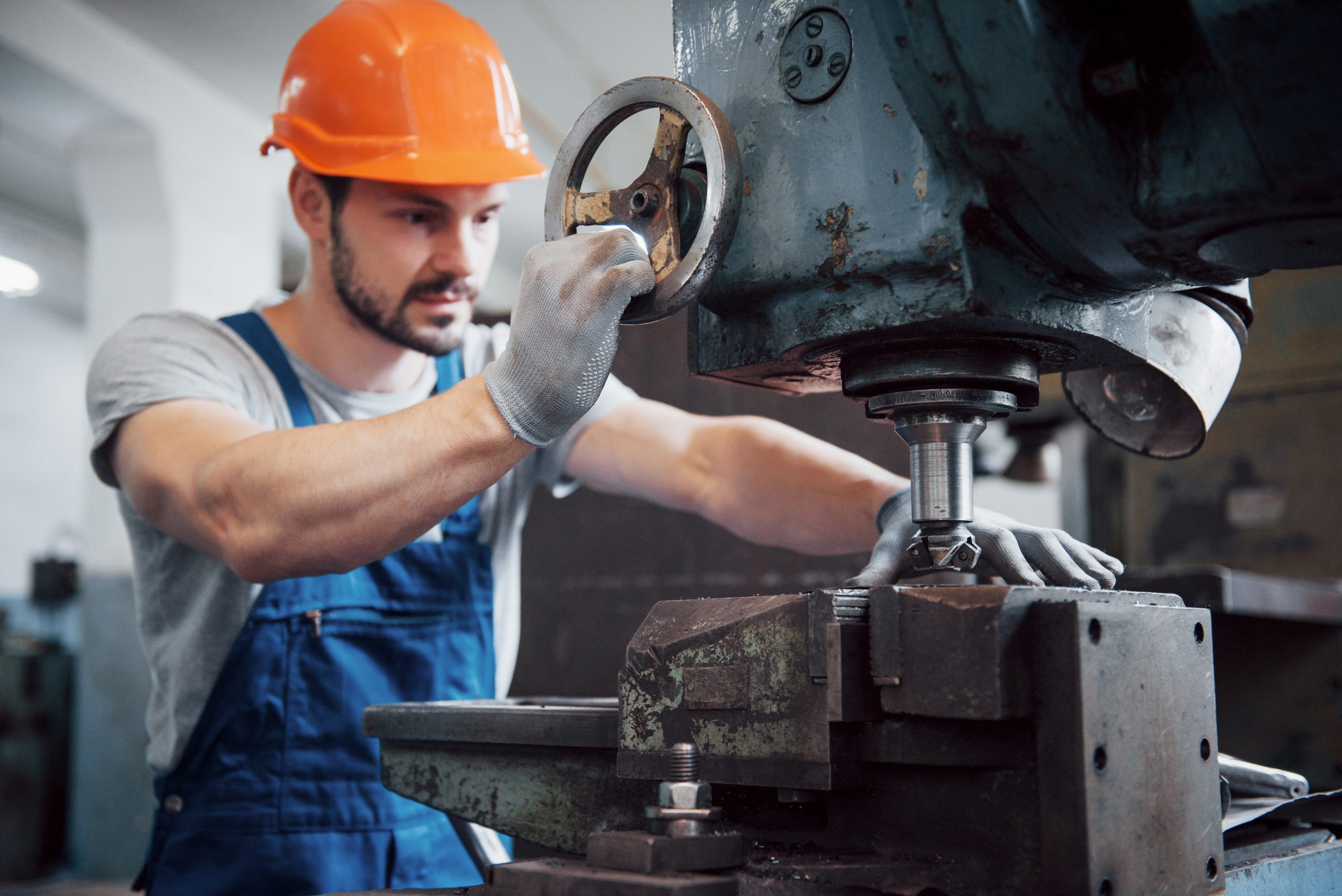 portrait-of-a-young-worker-in-a-hard-hat-at-a-large-metalworking-plant-the-engineer-serves-the-machines-and-manufactures-parts-for-gas-equipment